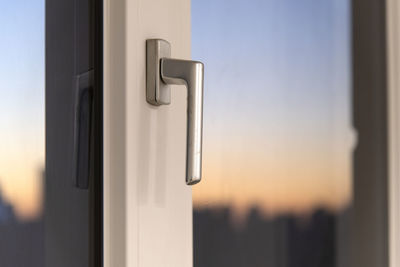 Close-up of  door handle against clear sky during sunset