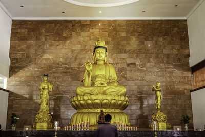 Low angle view of statue against illuminated building