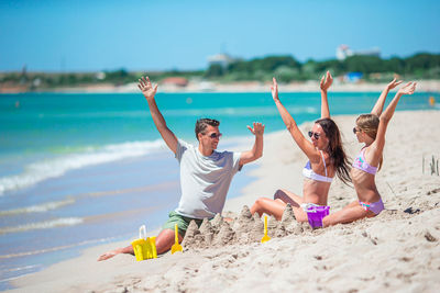 Full length of young woman doing yoga at beach