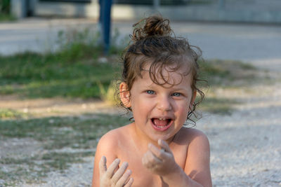 Portrait of happy girl sitting at beach 