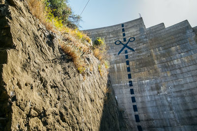 Low angle view of text on wall against building