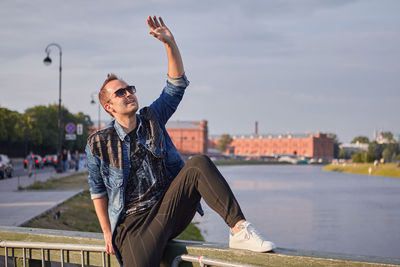 Smiling man looking up against river and sky