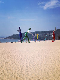 People enjoying on beach against sky