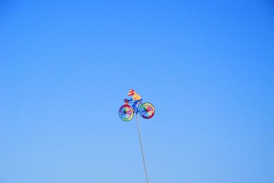 Low angle view of colorful toy against clear blue sky