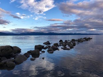 Rocks on sea shore against sky