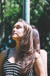 Close-up of young woman against trees