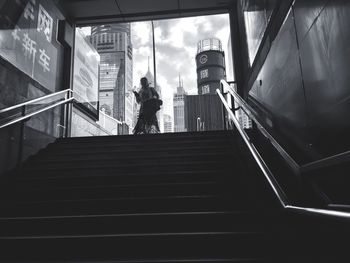 Low angle view of woman standing on escalator