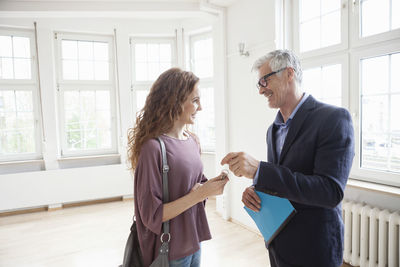 Real estate agent handing over key to client