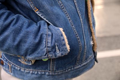 Midsection of person wearing denim jacket