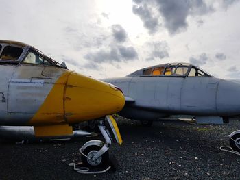 Airplane on airport runway against sky