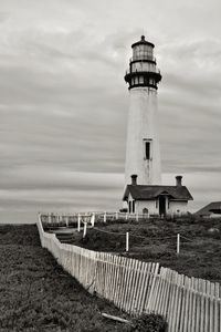 Lighthouse by sea against sky