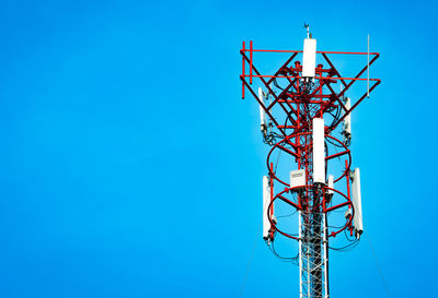 Low angle view of communications tower against clear blue sky