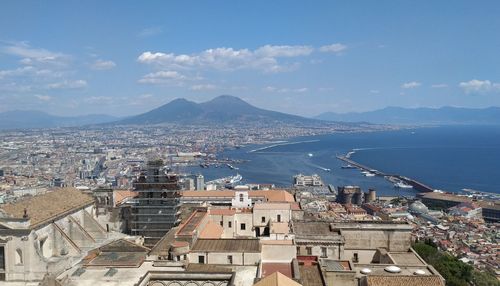 High angle view of townscape by sea against sky