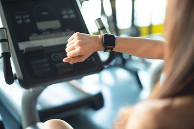 Close-up of woman wearing smart watch in gym
