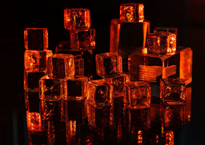 Close-up of illuminated candles against black background