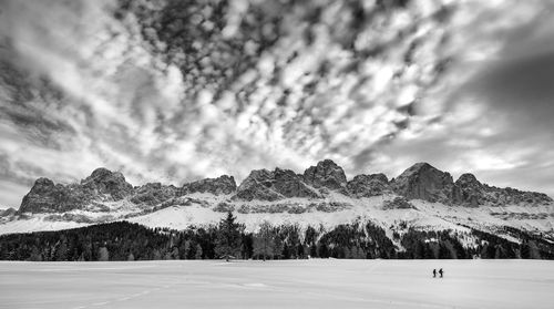 Scenic view of snow covered mountain dolomites against cloudy sky