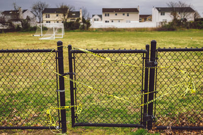 Fence on field by buildings