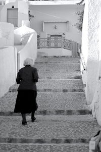 Rear view of woman standing on staircase of building