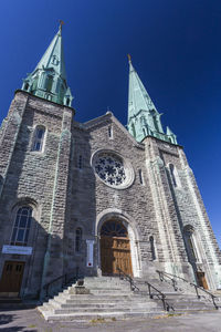 Low angle view of bell tower against blue sky