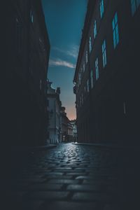 Surface level of street amidst buildings against sky at night