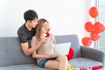 Young couple sitting on sofa at home