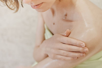 Woman applying body butter on her shoulder. shea butter for smooth skin. home spa and me time 