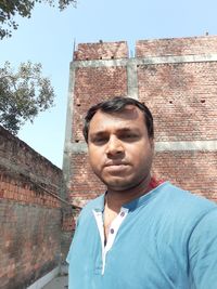 Portrait of man against wall against building