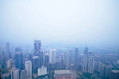 Aerial view of buildings in city against sky