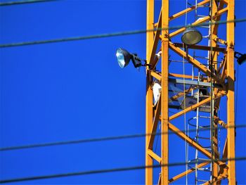 Low angle view of telephone pole against blue sky