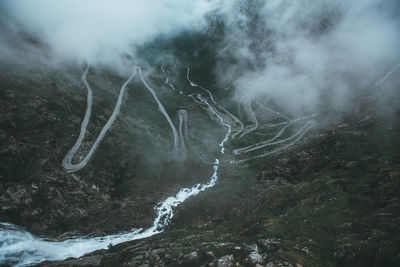 Scenic view of waterfall and winding mountain road 
