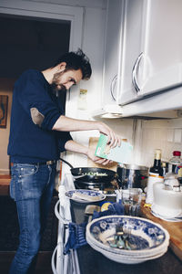 Side view of man cooking in kitchen at home