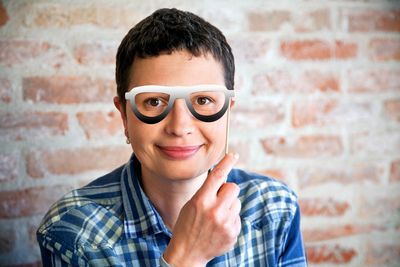 Portrait of a smiling young man against wall