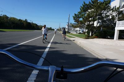 Man riding bicycle on road against sky