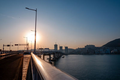 City by sea against clear sky during sunset
