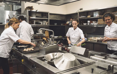 Chefs preparing food in commercial kitchen at restaurant