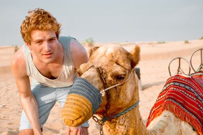 Portrait of  man in desert with camel