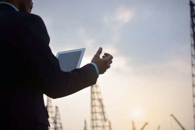 Man using mobile phone against sky