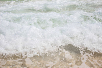 High angle view of waves splashing on beach