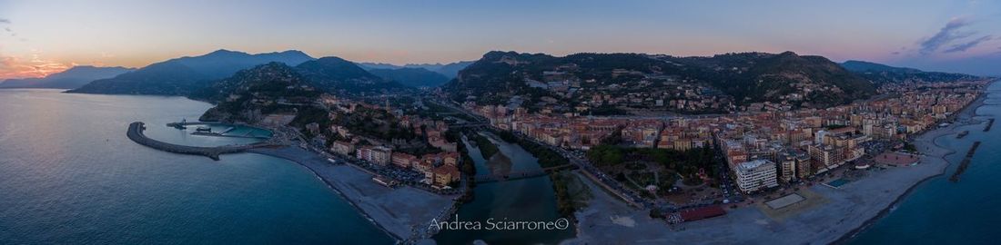 Panoramic view of city at waterfront during sunset