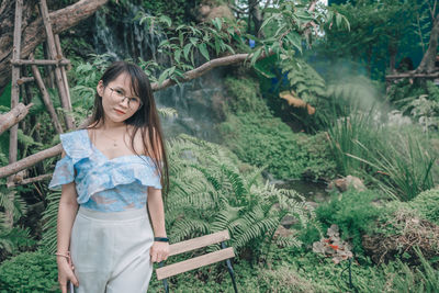 Portrait of woman standing against plants