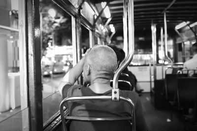 Rear view of mature man sitting in train