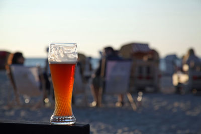 Close-up of beer glass at beach
