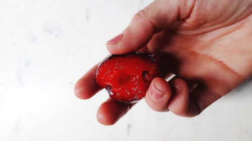 Close-up of hand holding strawberry