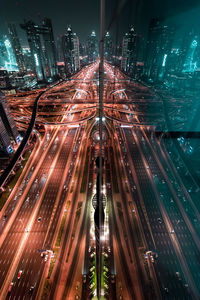 High angle view of light trails on road against buildings at night
