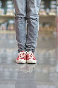 Low section of woman standing on floor at store