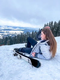 Shot of a skier woman sitting on the ski slope resting relaxing extreme recreation active lifestyle