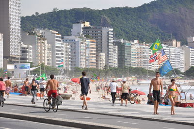 Group of people walking on road along buildings