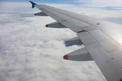 Airplane flying over clouds against sky