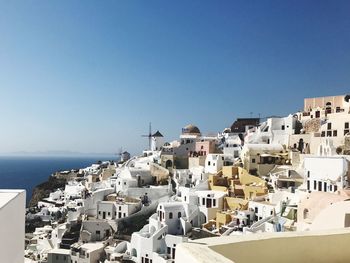 High angle view of houses in town against clear blue sky