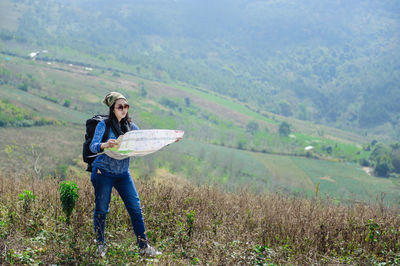 Full length of man holding umbrella on field